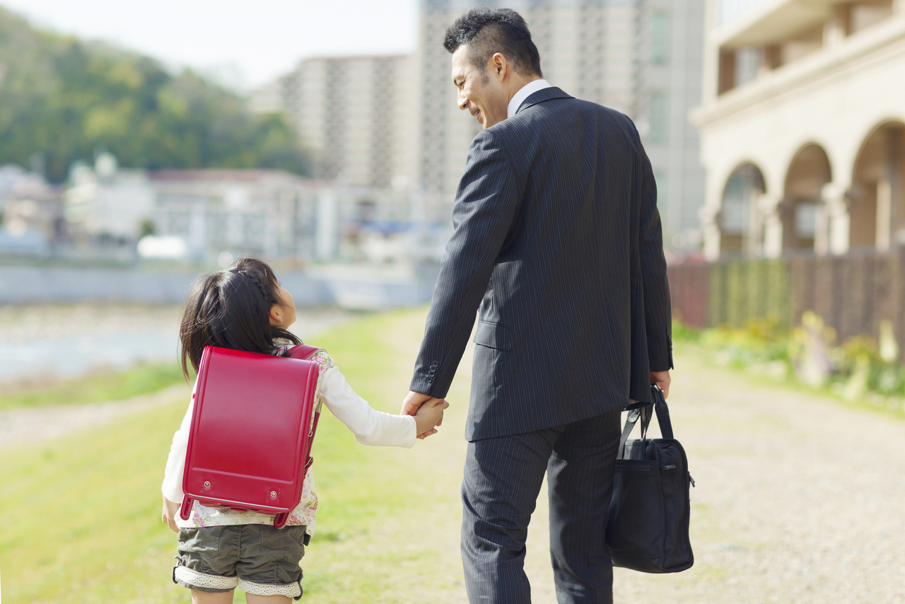 子供を小学校に送るお父さん