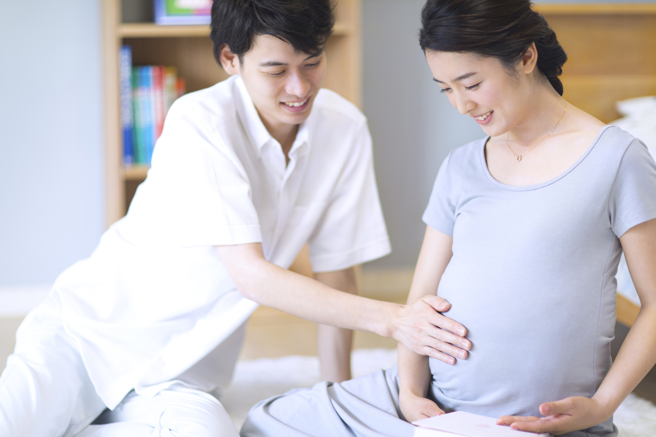 奥様の大きなお腹を摩る夫